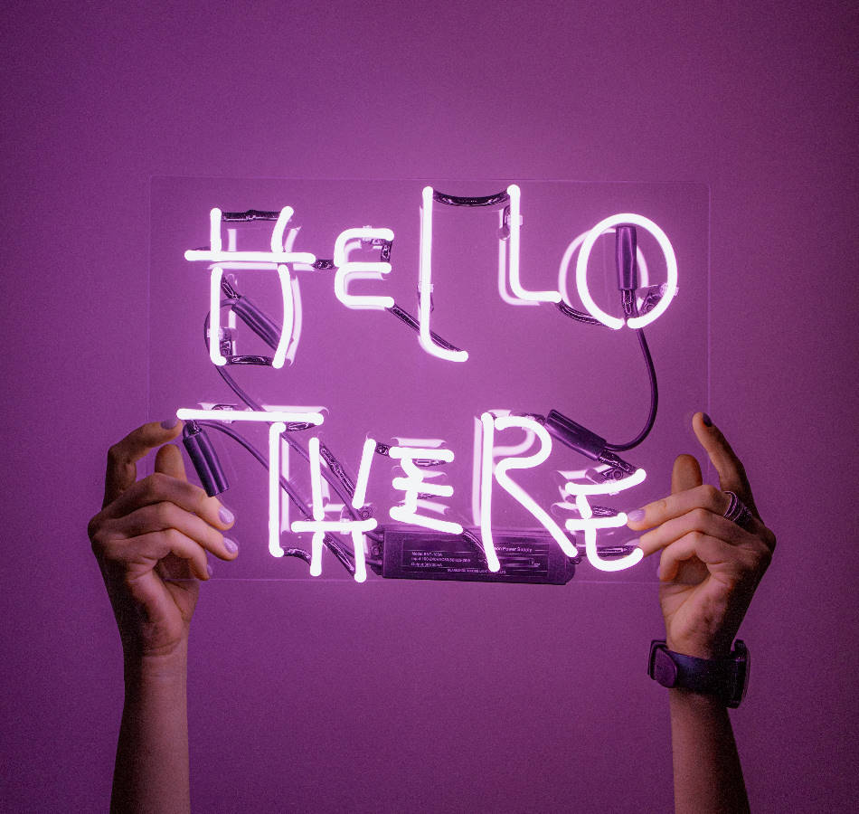 Hands holding violet neon typography